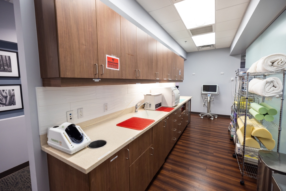 img slider photo 6 new Modern dental operatory with wood cabinetry, white countertop, and clinical equipment in bright, clean setting.