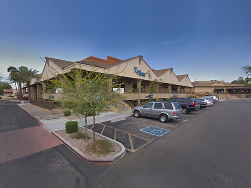 dc980f80-sk Kind Family Dentistry Scottsdale exterior building with parking lot and landscaping under blue sky.