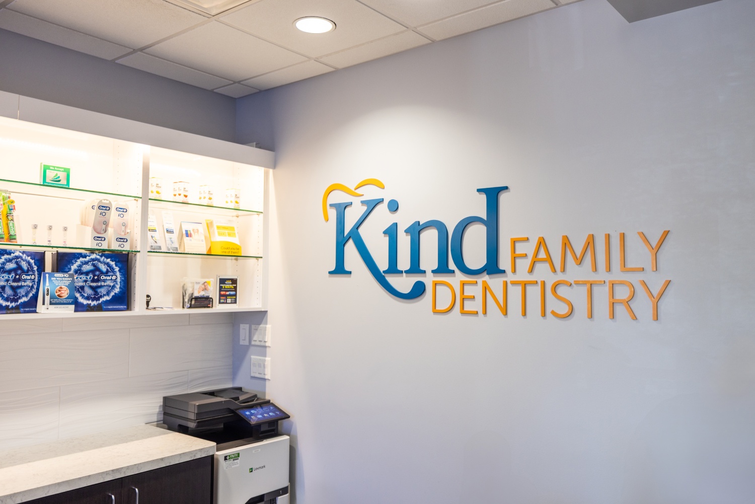 img slider photo 7 new Kind Family Dentistry reception area with logo on wall and dental office interior